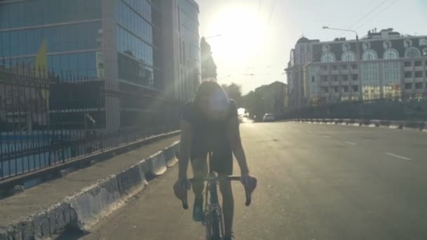 Jovem bonito homem montando uma bicicleta na cidade câmera lenta — Vídeo de Stock