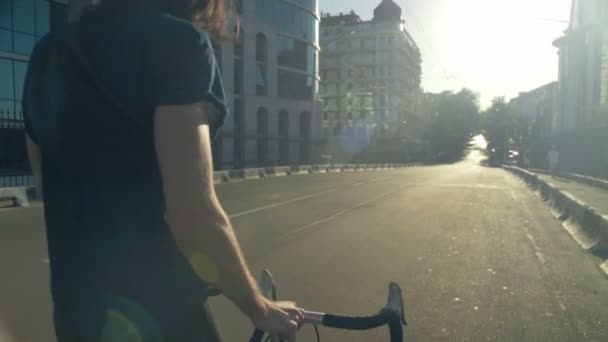 Jovem indo na estrada perto de sua bicicleta câmera lenta — Vídeo de Stock