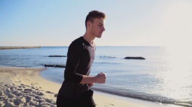 plaj yavaş hareket üzerinde koşan genç adam