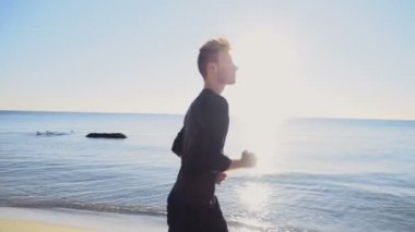 plaj yavaş hareket üzerinde koşan genç adam