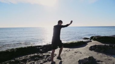 plaj yavaş hareket jimnastik yapan genç erkek