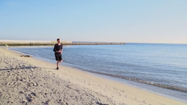 Young man running on the beach slow motion — Stock Video