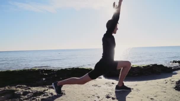 Ung man gör yoga på stranden slow motion — Stockvideo