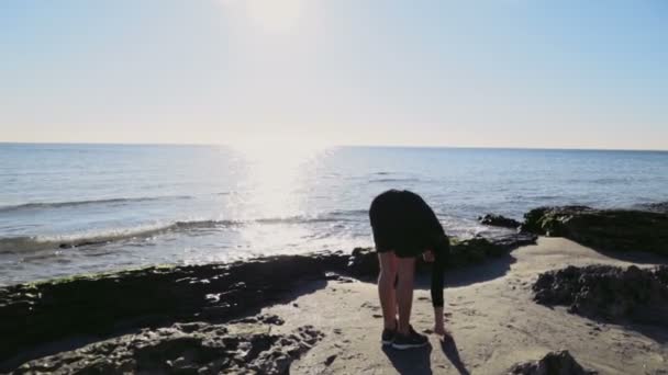 Giovane che fa ginnastica sulla spiaggia rallentatore — Video Stock