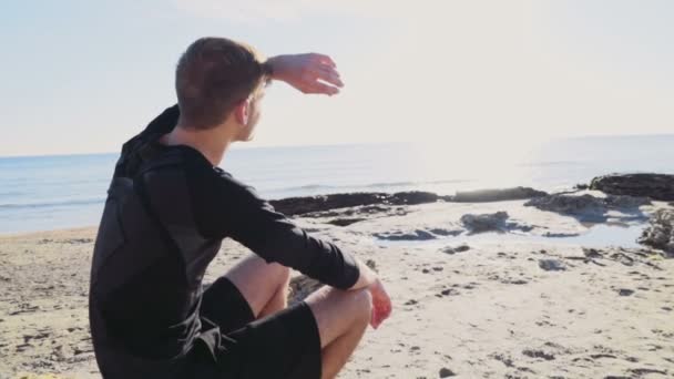 Молодой спортсмен наслаждаясь видом на море и солнце на пляже замедленного движения — стоковое видео