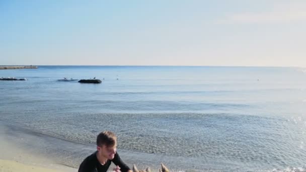 Jeune homme avec deux chiens husky sur la plage au ralenti — Video