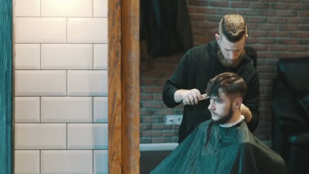 Barber coupe les cheveux du client avec une tondeuse — Video