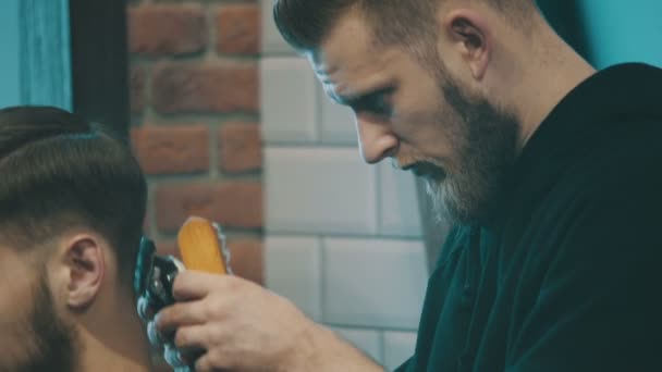 Barbeiro corta o cabelo do cliente com clipper — Vídeo de Stock