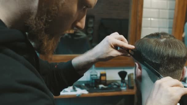 Peluquero corta el cabello del cliente con tijeras — Vídeos de Stock