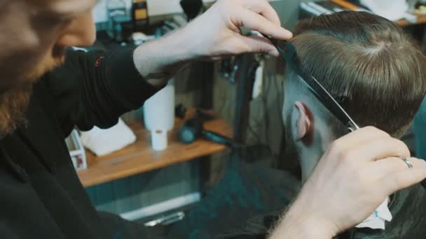 Barber cuts the hair of the client with scissors — Stock Video