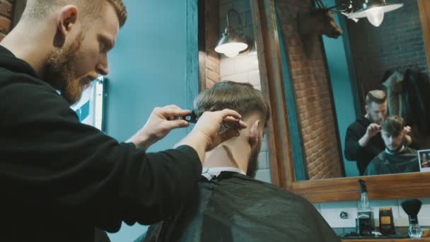 Peluquero corta el cabello del cliente con tijeras — Vídeos de Stock