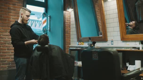 Barber shave the beard of the client with trimmer — Stock Video