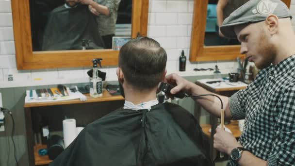 Barbeiro corta o cabelo do cliente com aparador — Vídeo de Stock