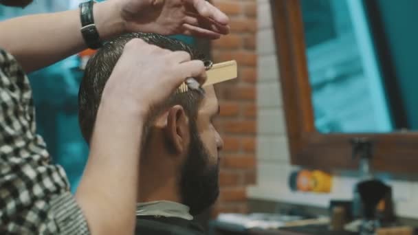 Barbeiro corta o cabelo do cliente com tesoura — Vídeo de Stock