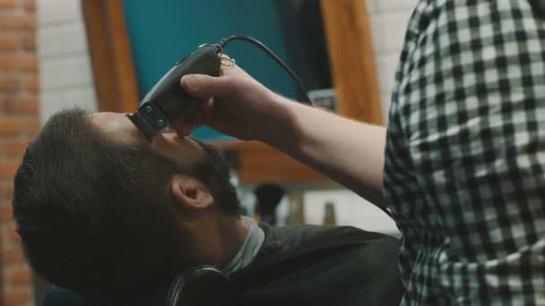 Barbeiro barbear a barba do cliente com aparador — Vídeo de Stock