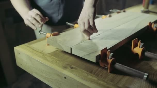 Joiner glues two workpiece of wooden plank together — Stock Video