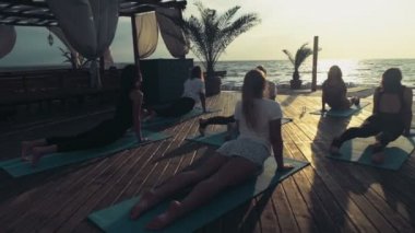 pratik yoga plaj yavaş hareket üzerinde kadın grubu