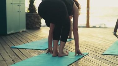 pratik yoga plaj yavaş hareket üzerinde kadın grubu