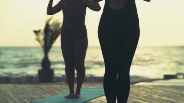 pratik yoga plaj yavaş hareket üzerinde kadın grubu