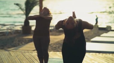 pratik yoga plaj yavaş hareket üzerinde kadın grubu