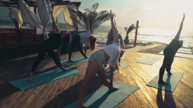 pratik yoga plaj yavaş hareket üzerinde kadın grubu