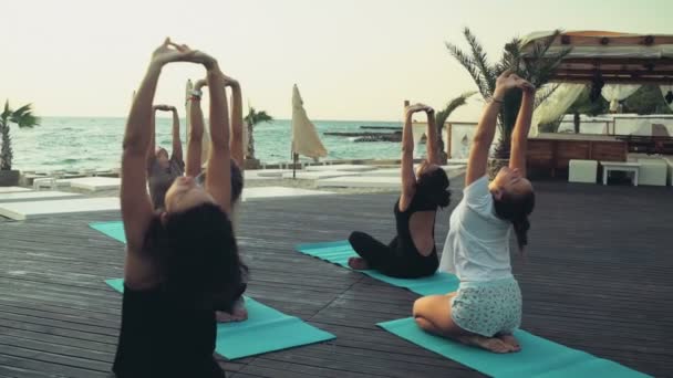 Groep vrouwen beoefenen van yoga op het strand slow motion — Stockvideo