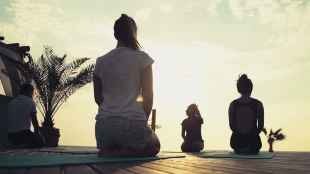 Kelompok wanita berlatih yoga di pantai gerak lambat — Stok Video