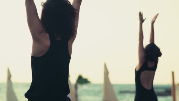 Grupo de mujeres practicando yoga en la playa cámara lenta — Vídeos de Stock