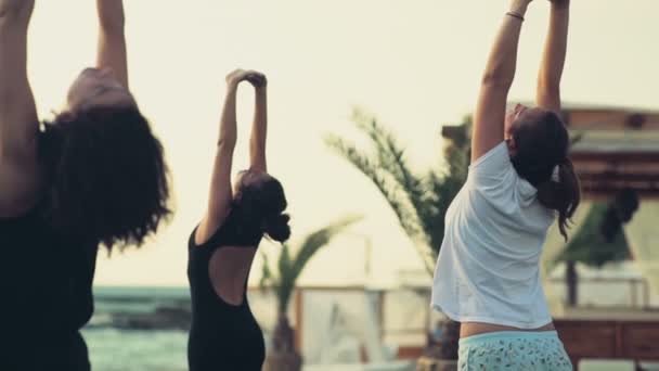 Skupina žen cvičí jógu na pláži Zpomalený pohyb — Stock video