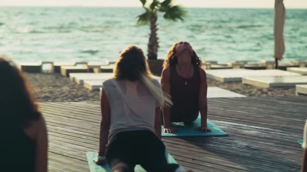 Pratik yoga plaj yavaş hareket üzerinde kadın grubu — Stok video