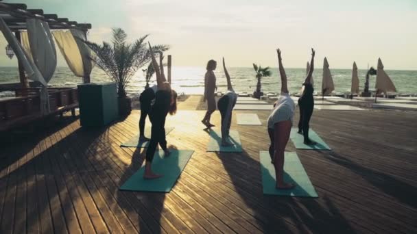 Gruppe von Frauen praktiziert Yoga am Strand Zeitlupe