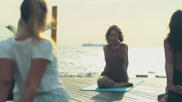 Grupo de mulheres praticando ioga na praia câmera lenta — Vídeo de Stock