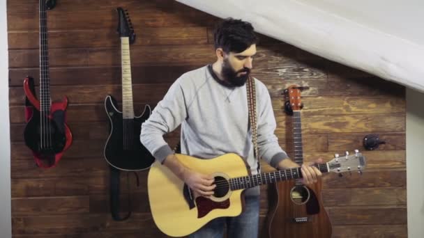 Бородатый человек играет на акустической гитаре замедленной съемки — стоковое видео