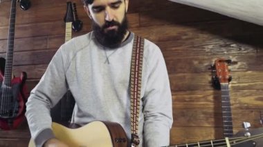 akustik gitar yavaş oynayan yakışıklı sakallı adam
