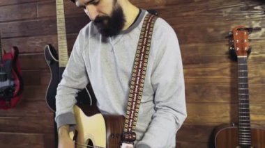 akustik gitar yavaş oynayan yakışıklı sakallı adam