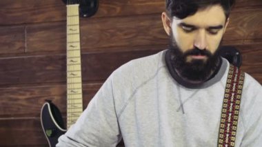 akustik gitar yavaş oynayan yakışıklı sakallı adam