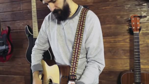 Bell'uomo barbuto che suona la chitarra acustica slow motion — Video Stock