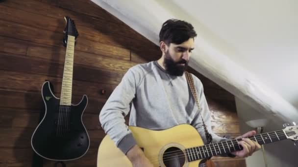 Красивый бородатый мужчина играет на акустической гитаре замедленной съемки — стоковое видео