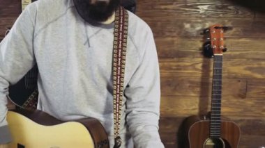 akustik gitar yavaş oynayan yakışıklı sakallı adam