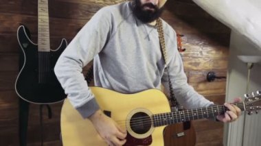 akustik gitar yavaş oynayan yakışıklı sakallı adam