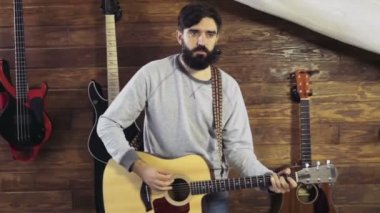 akustik gitar yavaş oynayan yakışıklı sakallı adam