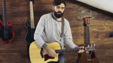 akustik gitar yavaş oynayan yakışıklı sakallı adam