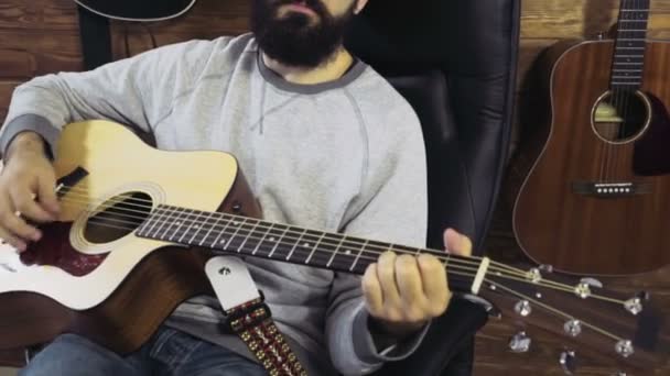 Красивый бородатый мужчина играет на акустической гитаре замедленной съемки — стоковое видео