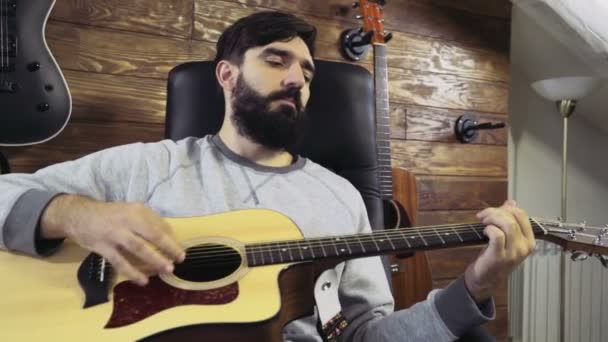 Bonito barbudo homem tocando o acústico guitarra lento movimento — Vídeo de Stock