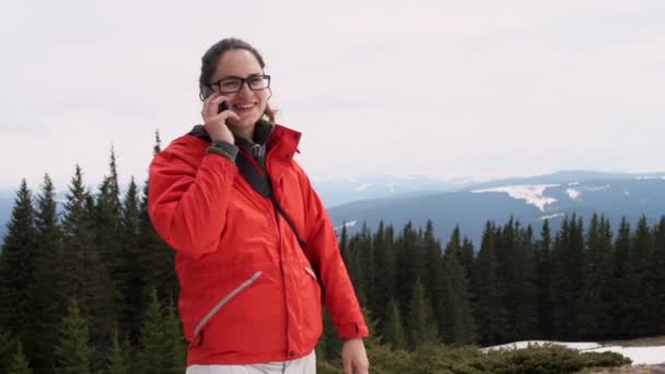 Mujer joven haciendo una llamada telefónica en las montañas — Vídeos de Stock