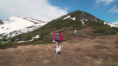 bir tepeye yükselen backpackers grup