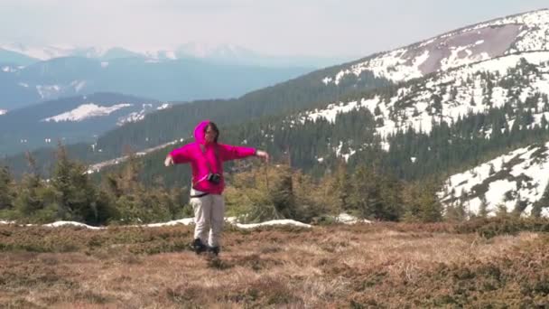 Женщина-туристка позирует для фото в горах замедленной съемки — стоковое видео