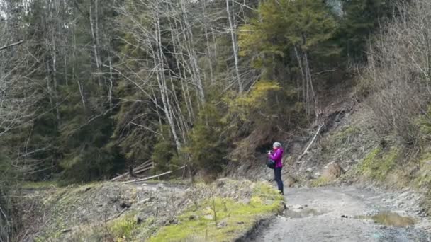 Жінка використовує камеру в лісі — стокове відео