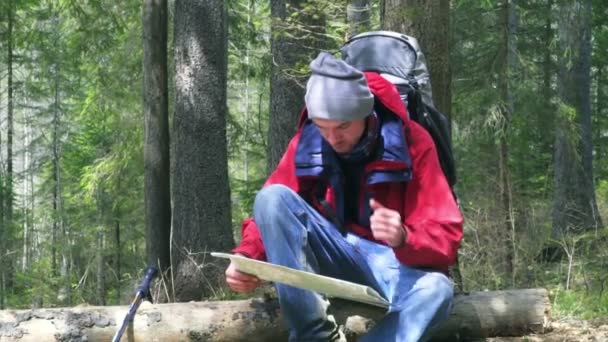 Excursionista viendo el mapa en el bosque — Vídeos de Stock