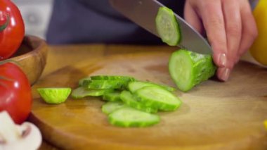 Şef salata closeup ağır çekim için bir salatalık doğrama